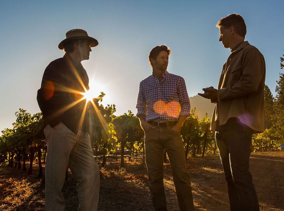 Founders of Obsidian Wine Co talking in the vineyard at sunset